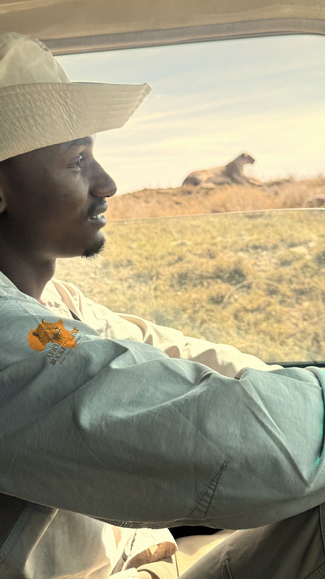 Guide Africa Bucket List observant la savane depuis son 4x4 en Tanzanie